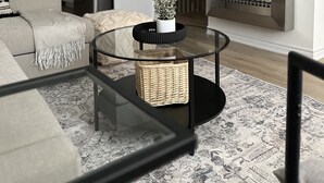 Un salon moderne avec un canapé, une table basse en verre, une cheminée et un téléviseur à écran plat fixé au mur.