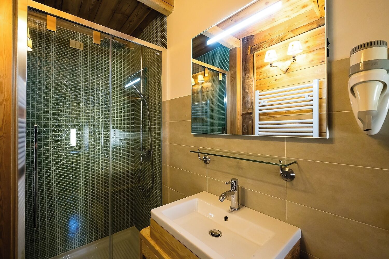 Une salle de bain moderne avec une douche à parois de verre, un lavabo beige et un miroir avec un cadre en bois.