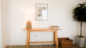 A wooden table with a lamp, a framed picture, and a potted plant. - Updated Home Walkable to Oceanfront! (Virginia Beach)