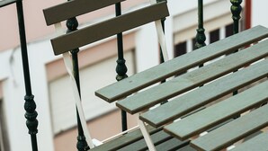 A metal-framed outdoor table with a bench on a tiled patio. - Cristina Apartment - Near the Beach (Armação de Pêra)