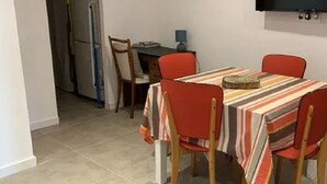 A dining area with a striped tablecloth, red chairs, and a wooden table.