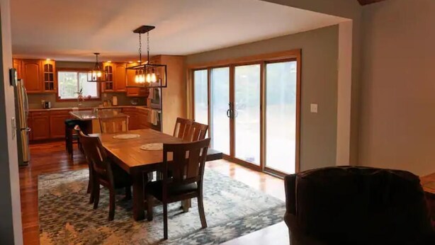 A spacious kitchen with wooden cabinets, a dining table, and chairs. - Spacious yet cozy house close to Gore Mountain

 (Johnsburg)