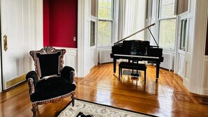 A grand piano in a room with red walls and large windows. - The Hamilton Hoppin House (Middletown)