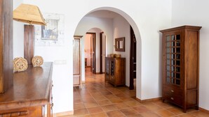 Ein Flur mit einem Holzkabinett, einer Lampe und einem gerahmten Bild an der Wand.