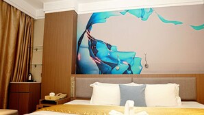 A hotel room with a bed, a nightstand, a telephone, and a wall painting. - Pristinehotel (Manila)
