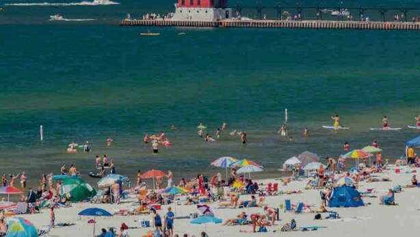 A beach with a pier and a lighthouse. - Grand Haven Getaway Welcomes You (Grand Haven)