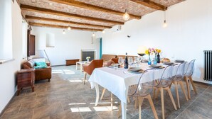 A dining area with a long table set for six, surrounded by wooden chairs. - Casa Leonarda 8+2, Emma Villas (Belveglio)