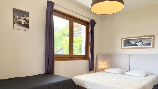 A bedroom with two beds, a window with curtains, a mounted picture, and a lamp. - LA Villa DES Tacounets (Saint-Gervais-les-Bains)
