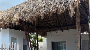 Un bâtiment doté d’un toit de chaume et d’une clôture en bois.
