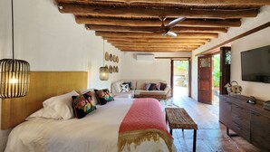 Un dormitorio con cama, mesita de noche, cómoda y televisor.