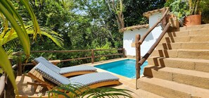 A pool area with wooden steps and lounge chairs. - Casa Yahri (Barichara)