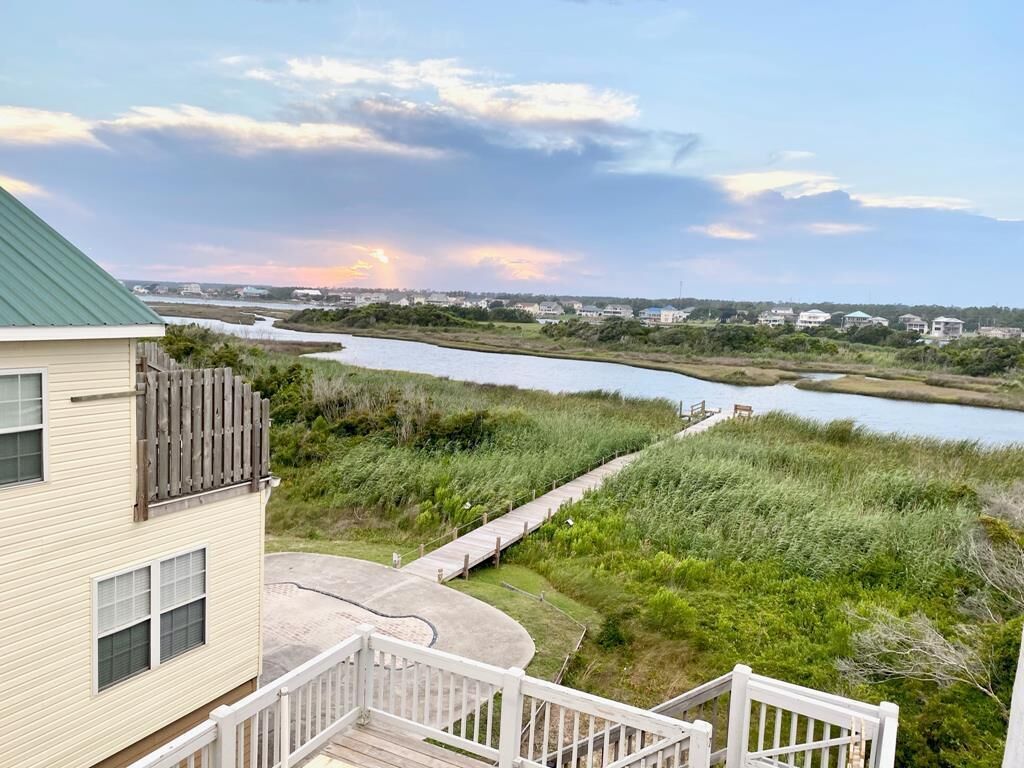 A house with a deck overlooking a river and marshland.