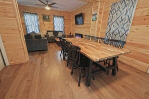 A wooden interior with a dining table, chairs, a sofa, and a ceiling fan. - Catskill House near downtown /w Hot tub, Sauna, Game room, Pool, Near Ski resort (Tannersville)