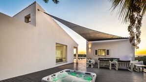 A rooftop patio with a hot tub, outdoor seating, and a view of the sunset. - Vila Dria: modern luxury in the best part of the Algarve (Silves)