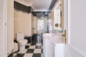 A bathroom with a toilet, sink, and shower.
