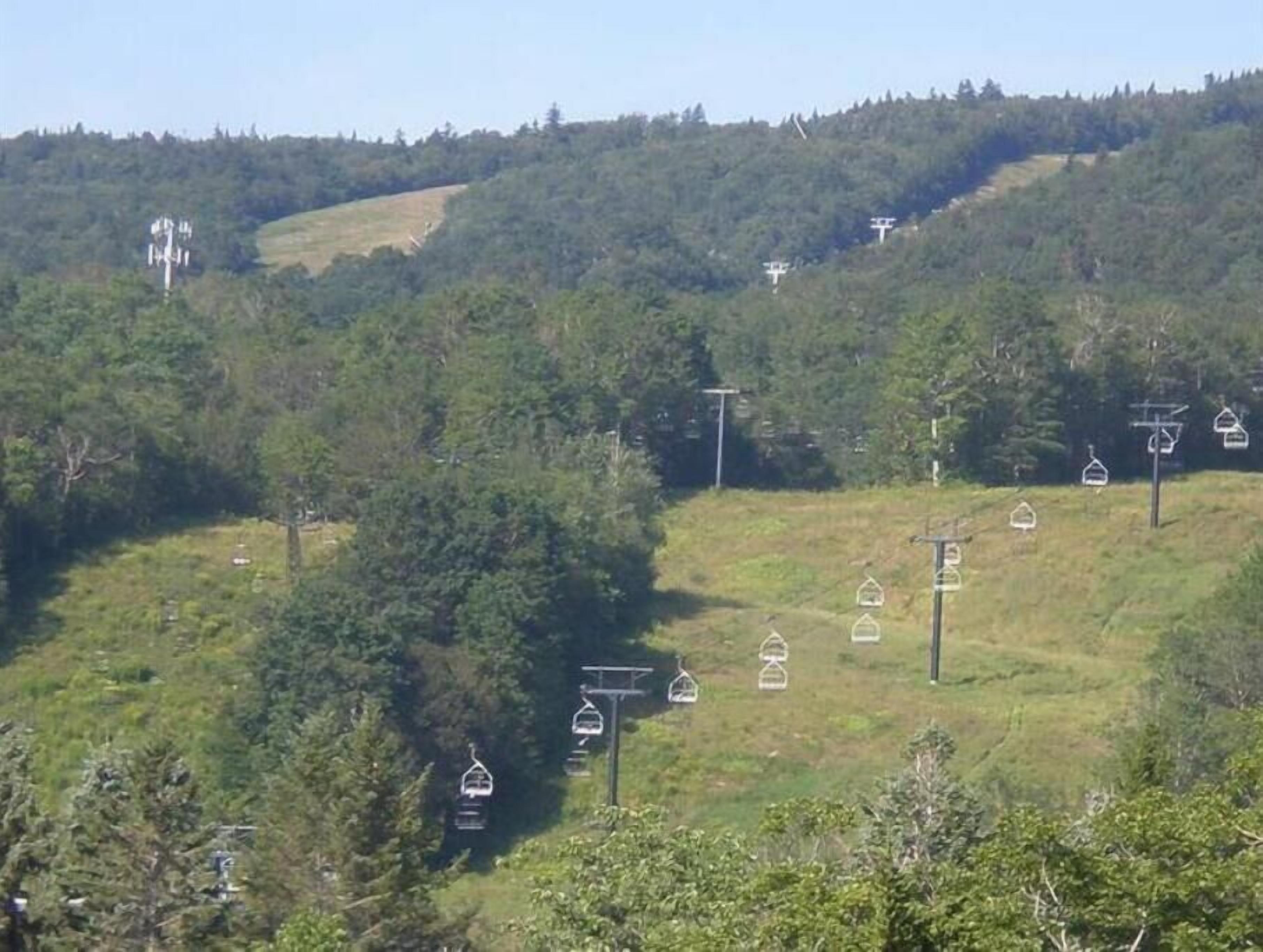 Een bergachtig gebied met meerdere skiliften en een heldere lucht.
