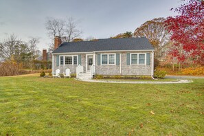 A single-story house with a front porch, a chimney, and a well-maintained lawn. - Rail Trail Access: Home 2 Mi to Lighthouse Beach! (Chatham)