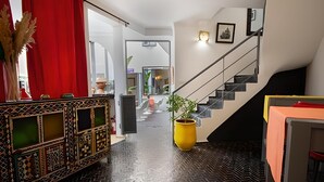 Un interior moderno con piso de espiga en color negro, una escalera y una consola decorativa.