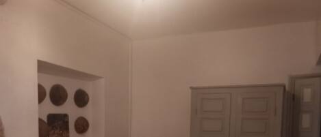 Une chambre à coucher comprenant un lit, une armoire et un mur décoré de motifs circulaires.