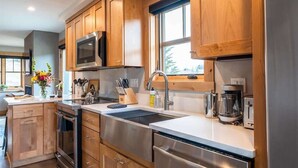 Una cocina moderna con armarios de madera, electrodomésticos de acero inoxidable y un ventanal grande.
