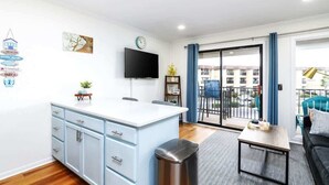 Un appartement moderne doté d’une cuisine, d’un coin repas et d’un balcon offrant une vue sur la ville.