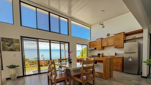A modern kitchen with wooden cabinets, a stainless steel refrigerator, and a large island. - 3bdr House in Uvita LAPA | 180° Ocean View (Bahía Ballena)
