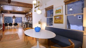 Un interior moderno con una mesa redonda blanca, un sofá azul y sillas de madera.