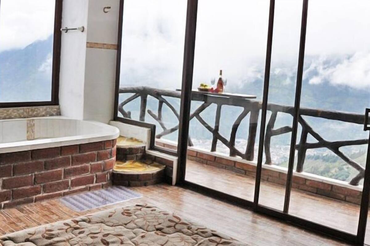 Zona de spa con jacuzzi y vistas a las montañas.