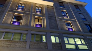 Un immeuble à plusieurs étages doté d’une architecture moderne, caractérisé par des fenêtres rectangulaires et un toit plat.