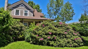 A house with a gabled roof, a chimney, and a well-maintained garden with flowering bushes. - Rustic Log with Pool Game room Amazing koi pound just mins from Hunter Mountain (Elka Park)