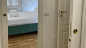 A bedroom with a bed, a window, and a door.