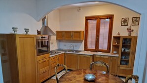 Una cocina con armarios de madera, una estufa y una mesa de comedor con sillas.