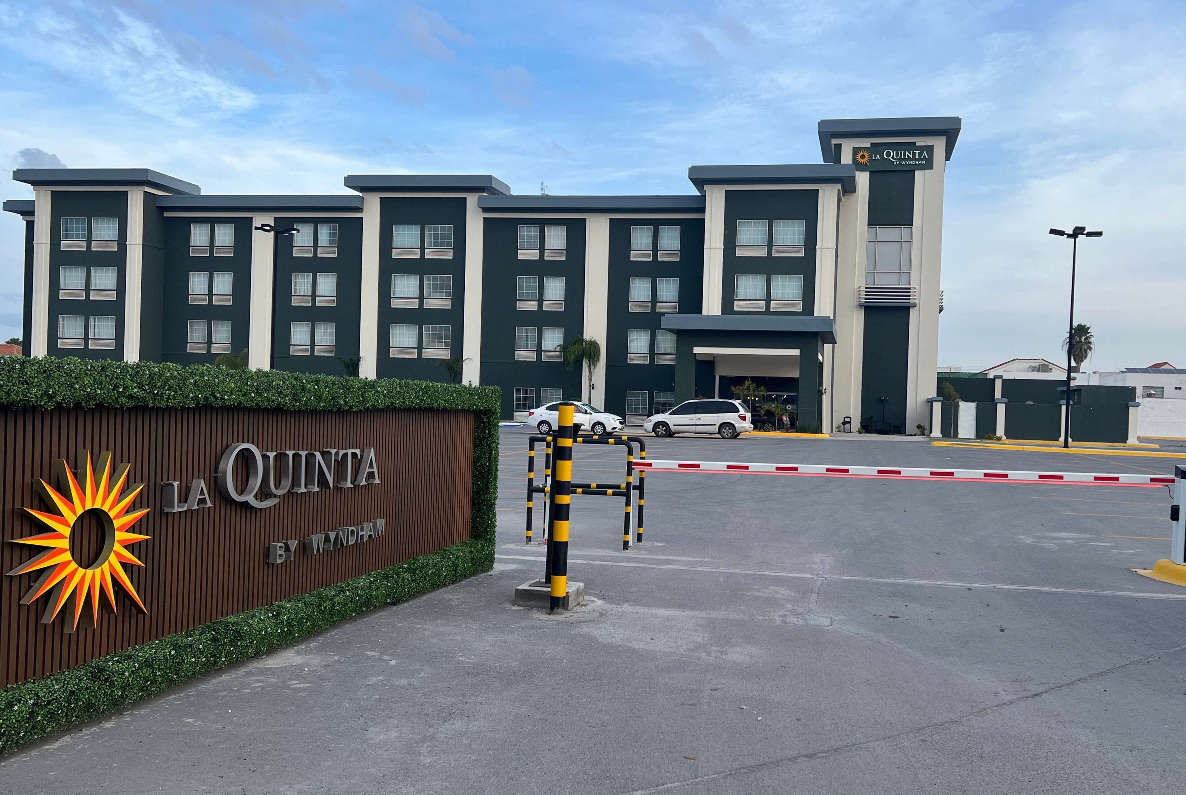 A hotel entrance with a gated driveway and a sign reading "La Quinta by Wyndham".