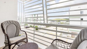 A balcony with a view of a parking lot and buildings.