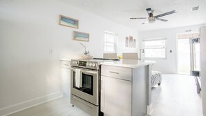 A modern kitchen with stainless steel appliances, white cabinetry, and a central island. - Charming 1-Bedroom Oasis in the Heart of Downtown (New Port Richey)