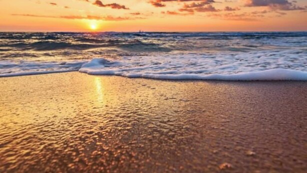 A beach with waves and a sunset. - Charming 1-Bedroom Oasis in the Heart of Downtown (New Port Richey)