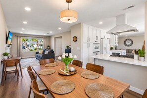 A modern kitchen with white cabinets, a central island, and a built-in oven. - Spacious Family Retreat · Views · Hot Tub · BBQ · Sleeps 6-10 (San Diego)
