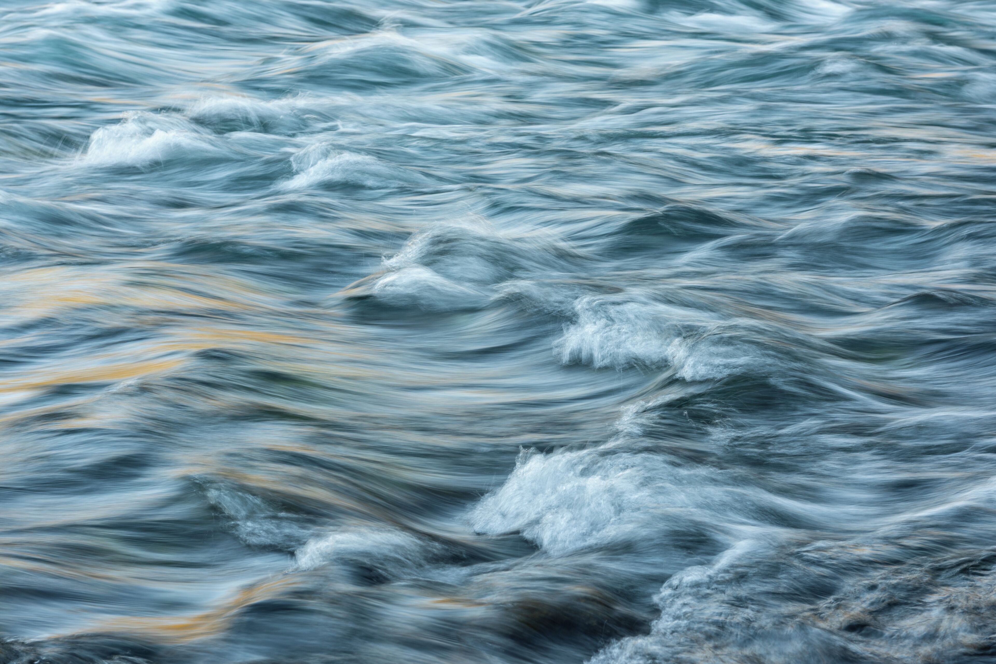 A close-up of turbulent water with visible motion blur.