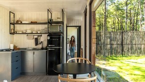 Una cocina moderna con electrodomésticos de acero inoxidable, armarios de madera y un amplio ventanal con vistas a un jardín.
