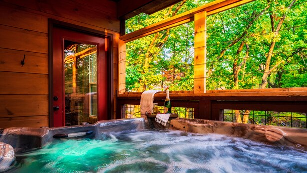 A hot tub with a view of trees through a window. - 3 King Beds 3.5 Bath Cabin-Hot Tub-Pool Table, Great Smoky Mountains (Sevierville)