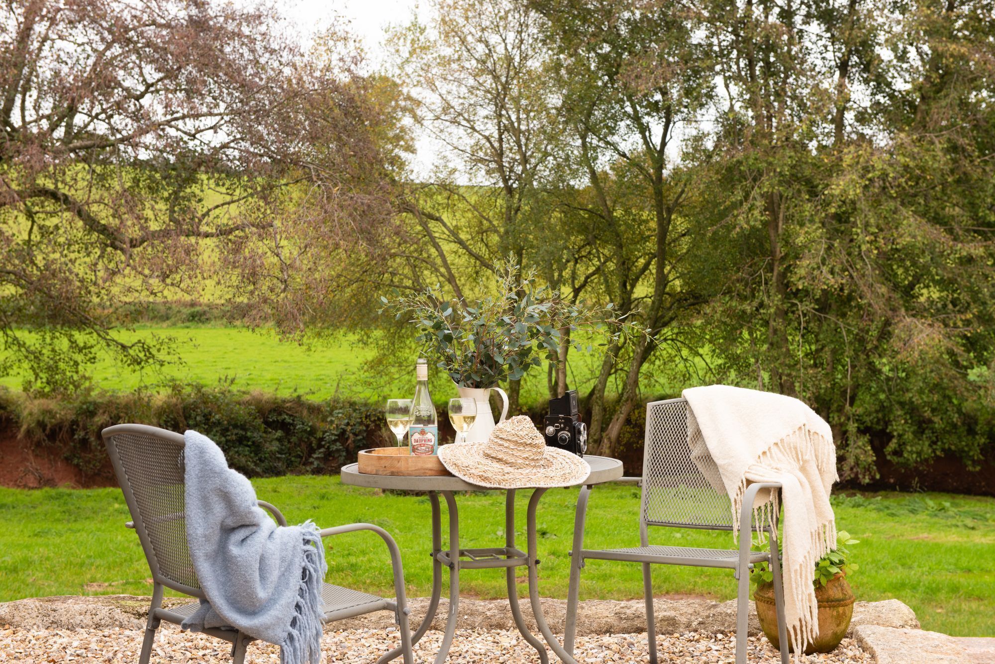 An outdoor seating area with a table, chairs, and a camera.