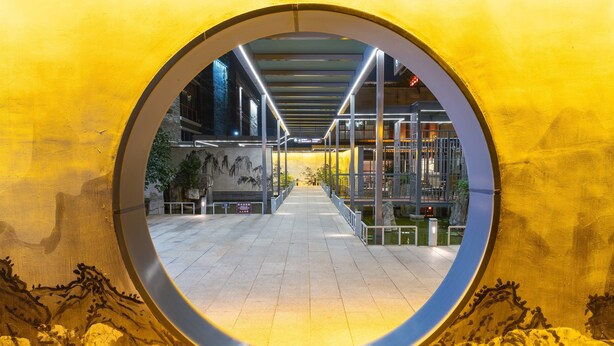 A circular viewing area with a pathway leading to a building with a glass facade and a mural. - Holiday Inn Express Pingchang by IHG (Bazhong)