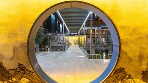 A circular viewing area with a pathway leading to a building entrance, surrounded by a yellow wall with a mural. - Holiday Inn Express Pingchang by IHG (Bazhong)