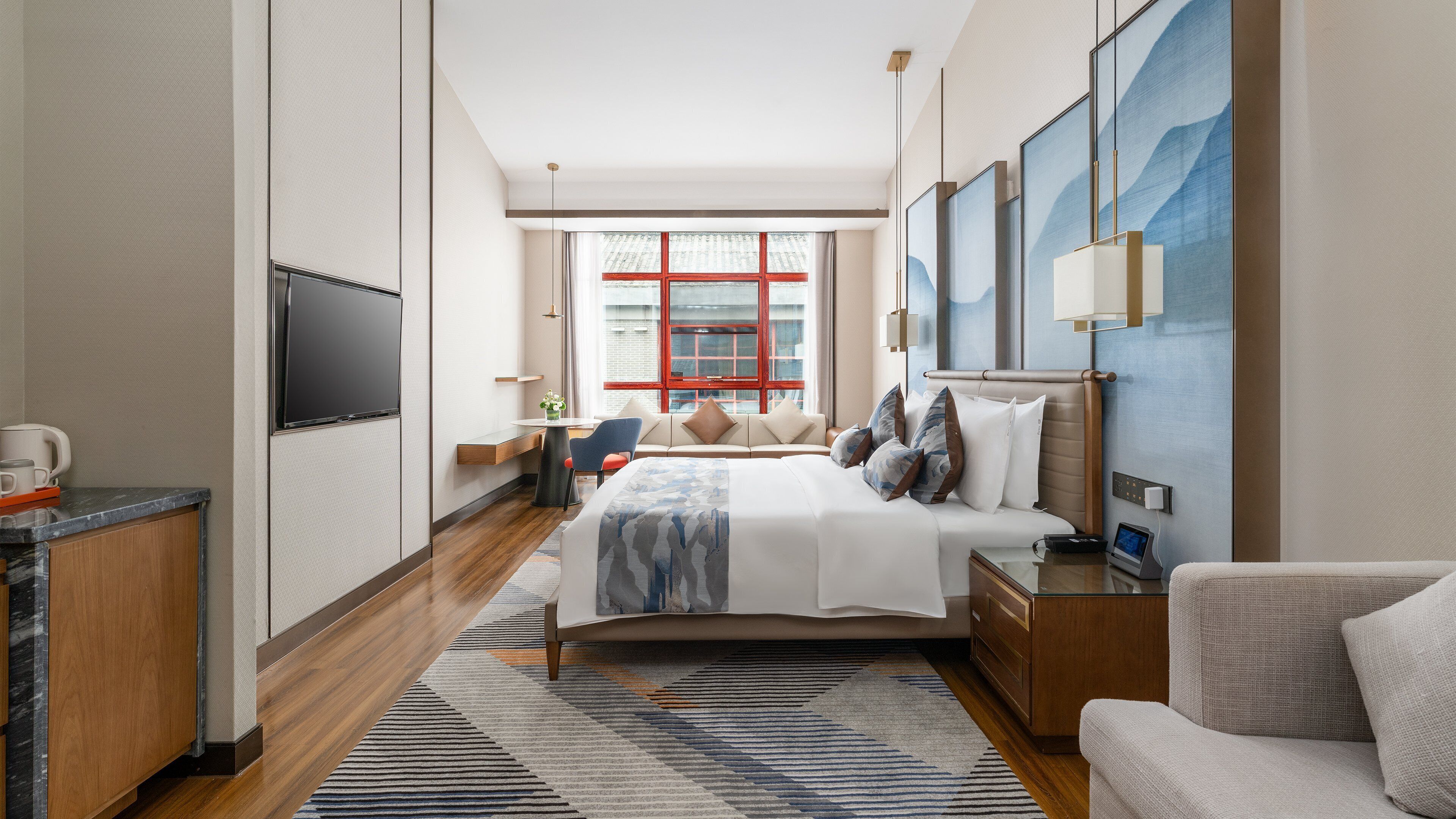 A hotel room with a bed, bedside tables, a TV, a window with curtains, and a view of the city.