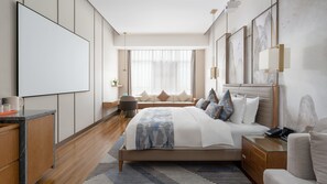 A modern hotel room with a large bed, a desk, and a seating area. - Holiday Inn Express Pingchang by IHG (Bazhong)