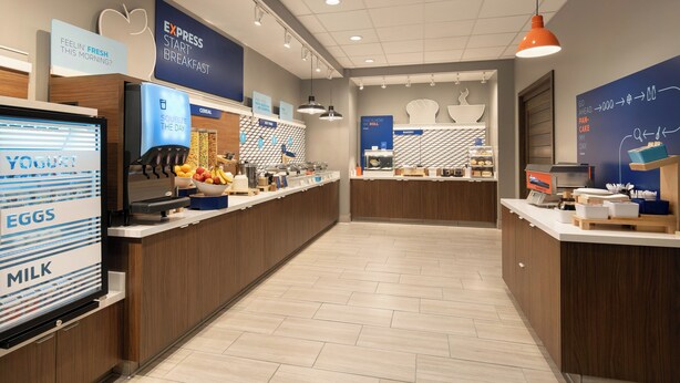 A modern breakfast area with a self-serve station, including yogurt, eggs, and milk. - Holiday Inn Express & Suites Fresno Airport by IHG (Fresno)
