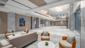 A spacious lobby with a reception desk, seating area, and a view of the upper floor. - Holiday Inn Express Quanzhou Taishang by IHG (Quanzhou)