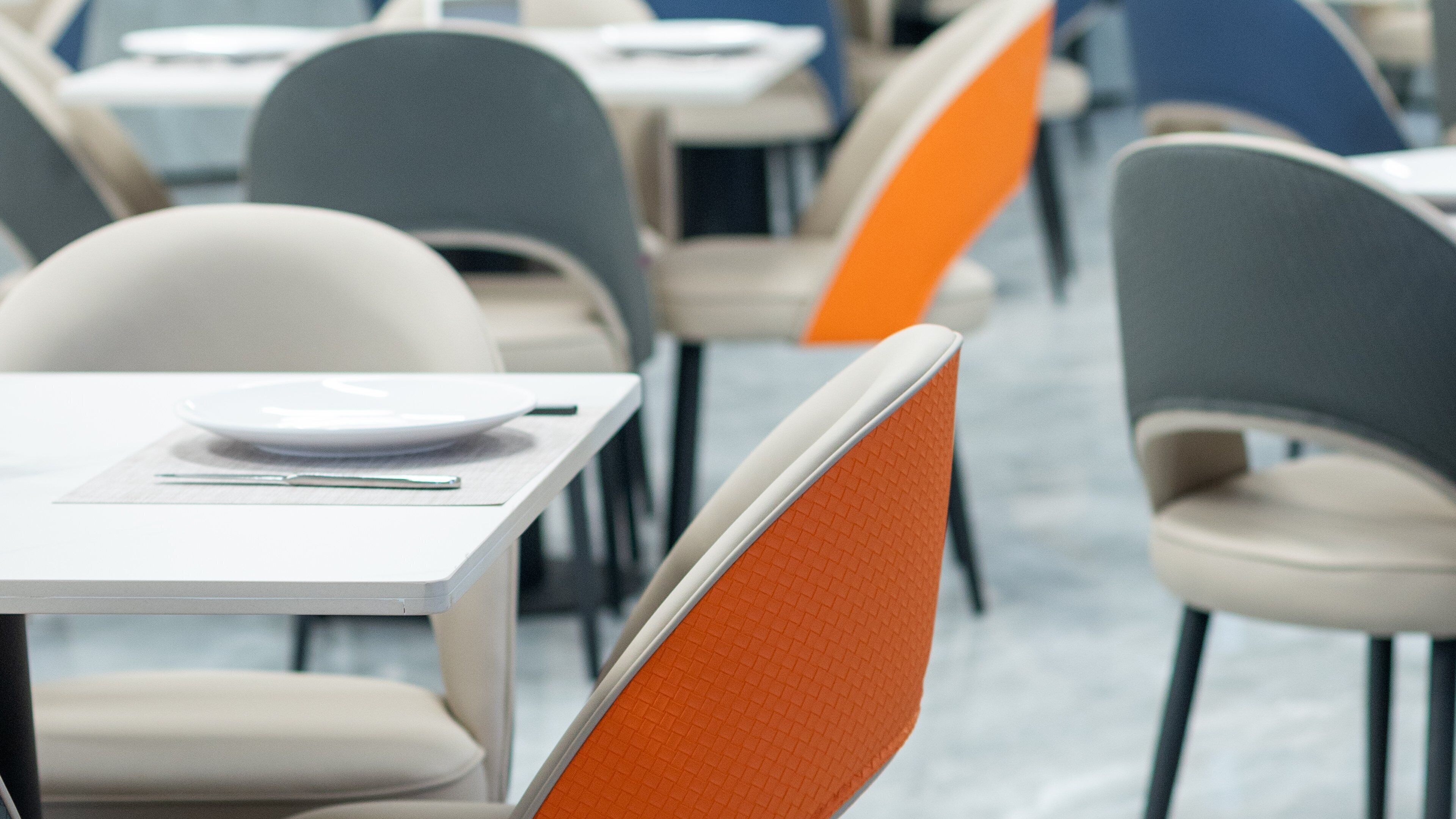 Un espace repas moderne avec des tables et des chaises.
