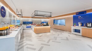 A modern breakfast area with a buffet setup, including fruit bowls and a juice dispenser. - Holiday Inn Express Quanzhou Taishang by IHG (Quanzhou)