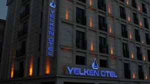 Un edificio de varios pisos con un letrero llamativo que dice 'Yelken Otel'.